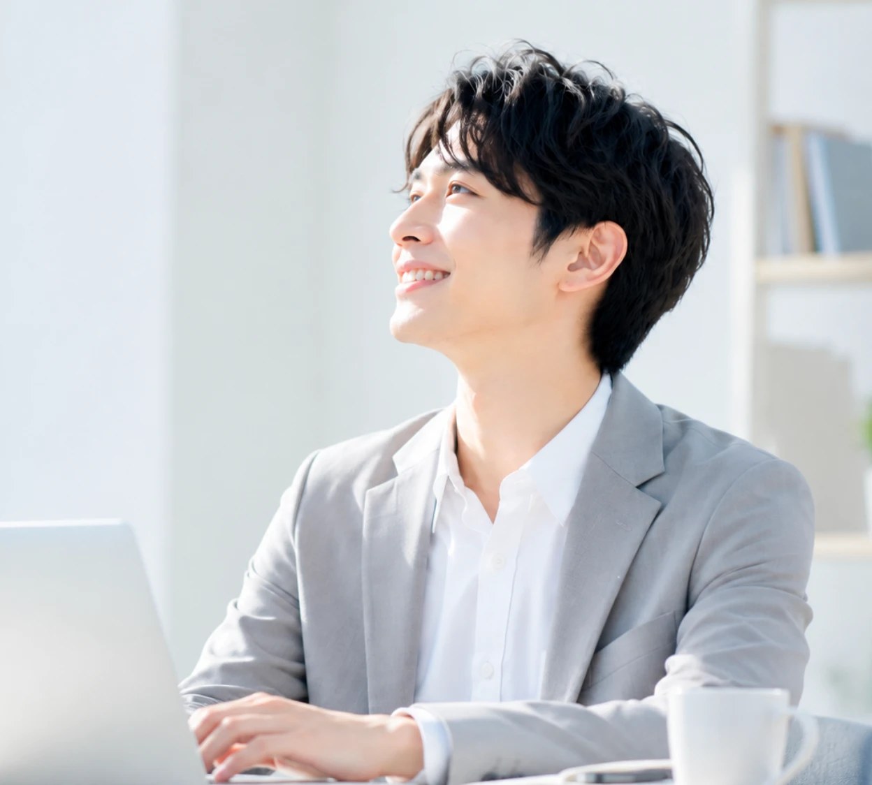 ノートパソコンに向かって微笑む男性